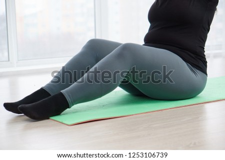 fitness, sport, weight loss, exercising, home workout, training, lifestyle. young plus size woman doing sit-ups on mat at home