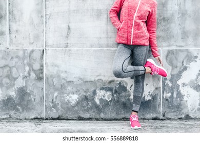 Fitness sport woman in fashion sportswear doing yoga fitness exercise in the city street over gray concrete background. Outdoor sports clothing and shoes, urban style.