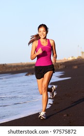 Fitness Sport Woman Running On Beach Outside At Sunset. Healthy Lifestyle Image Of Beautiful Young Asian Woman Jogging On Black Sand Beach.