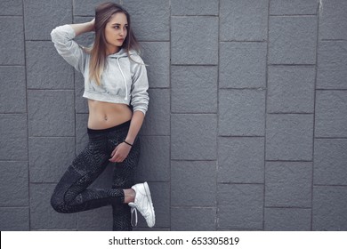 Fitness Sporty Girl Wearing Fashion Sportswear Over Street Wall, Outdoor Sports, Urban Style. Teen Model In Swag Clothes Posing Outside.