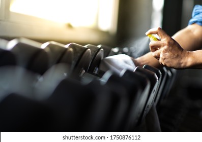 Fitness Staff Cleaning Exercise Machines Alcohol Sanitizer Spray At The Gym. Preventive Disease Of The Covid 19 Virus