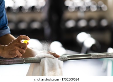 Fitness Staff Cleaning Exercise Machines Alcohol Sanitizer Spray At The Gym. Preventive Disease Of The Covid 19 Virus