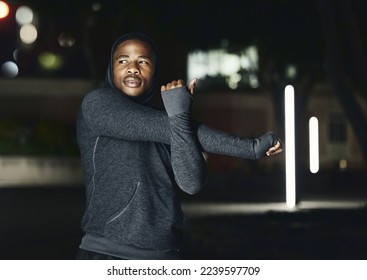 Fitness, stretching and black man in city at night do warm up for running, workout and marathon training. Sports, commitment and male stretch arms for health, motivation and ready to start exercise - Powered by Shutterstock