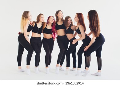Fitness, stretching practice, group of attractive happy smiling fit mature women working out in sports club, doing Extended Side Angle posture