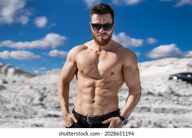 Fitness strongmen having workout outdoor in a rocky background. Bodybuilders concept background - muscular bodybuilder handsome man doing exercises outdoor. Half naked young man. Bare torso