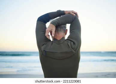 Fitness, surf and man stretching on beach to warm up before training in ocean water. Fitness, freedom and surfer with wellness, health and active lifestyle doing arm exercise for surfing at seaside. - Powered by Shutterstock