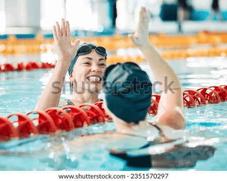 Fitness, swimmer and women with high five, celebration and achievement with workout, wellness and winning. Exercise, winner or champion in a pool, celebration or support with success, sports or smile