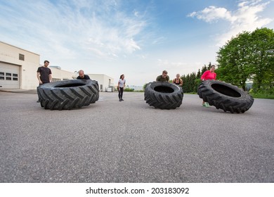 Fitness Team Flipping Heavy Tires Outdoor