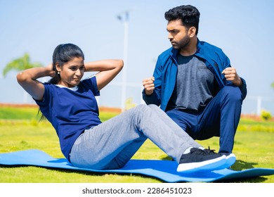 Fitness trainer encouraging or cheering up woman for exercising by pushing up limits - concept of motivation, guidance and athletic - Powered by Shutterstock