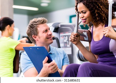 Fitness Training In Gym - Black Woman And Personal Trainer Exercising On Resistance Machine