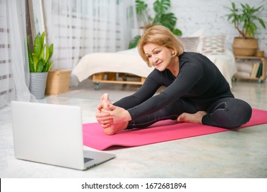 Fitness training online, senior woman at home with laptop. - Shutterstock ID 1672681894