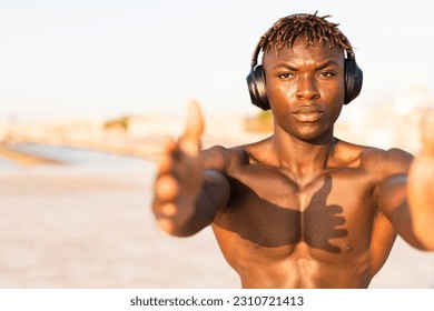 Fitness training outdoors. Handsome African man doing exercises outside. Muscular man training. - Shutterstock ID 2310721413