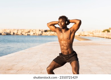 Fitness training outdoors. Handsome African man doing exercises outside. Muscular man training. - Shutterstock ID 2310721429