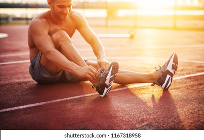 Fitness training outdoors. Handsome man working exercises in early morning with sunrise. Muscular man training outside. Sunny fitness morning. - Powered by Shutterstock