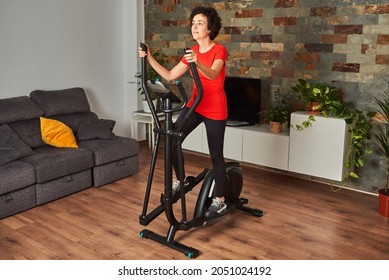 Fitness training woman at home training on smart elliptical cross trainer indoors - Powered by Shutterstock