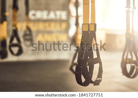 Fitness trx straps inside of a gym, functional training equipment and sport accessories
