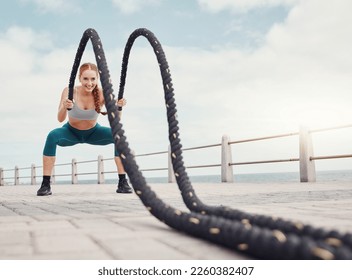 Fitness, woman and battle rope at the beach for intense arm workout, training or exercise in Cape Town. Active female exercising with ropes for cardio, muscle endurance or power in the outdoors - Shutterstock ID 2260382407
