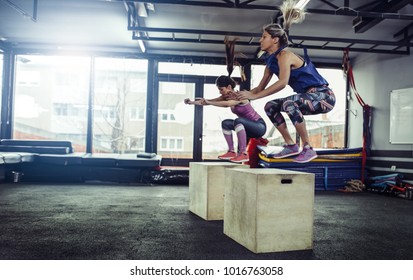 Fitness Woman Doing Box Jump Workout At Gym. Female Athletes Doing Box Jump Workout At Gym.