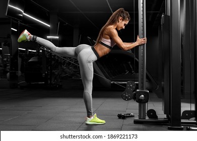 Fitness Woman Doing Exercise For Glutes, Cable Kickbacks. Athletic Girl Workout In Gym