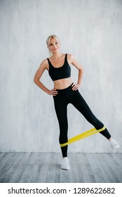 Fitness Woman Doing Leg Exercises With Yellow Fitness Gum
