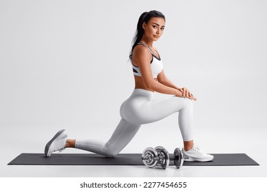 Fitness woman doing lunges exercises for leg muscle training. Active girl doing front forward one leg step lunge - Shutterstock ID 2277454655