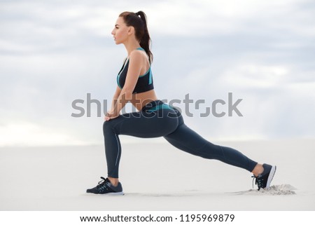 Fitness woman doing lunges exercises for leg muscle workout training, outdoor. Active girl doing front forward one leg step lunge exercise