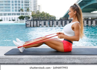 Fitness Woman Doing Resistance Band Exercise For Back Outdoors. Athletic Girl Working Out