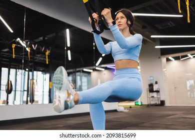 Fitness Woman Doing Squat Exercise And Training Legs With Trx Straps In Gym