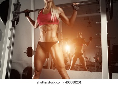 Fitness Woman Doing Squats With The Barbell At The Gym. Smith Machine In The Gym.  Fitness Woman In The Gym. Perfect Female Figure