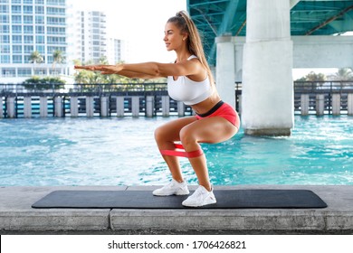 Fitness Woman Doing Squats Exercise For Glute With Resistance Band, Outdoors. Athletic Girl Workout