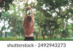 Fitness woman doing stretch exercise stretching her arms, female stretching for warming up before running or working out in the park outdoor, copy space