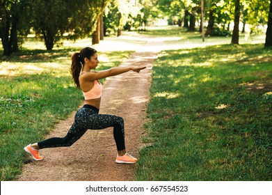 Fitness woman doing stretching exercise outdoors in park