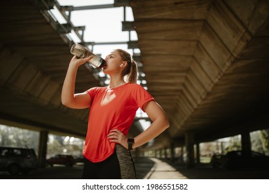 Fitness Woman Drinking Water From Bottle. Muscular Young Female Taking A Break From Workout Outside.