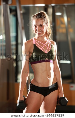 Similar – One young athletic woman at crossfit training, exercising with trx suspension fitness straps over dark background, front view, looking at camera