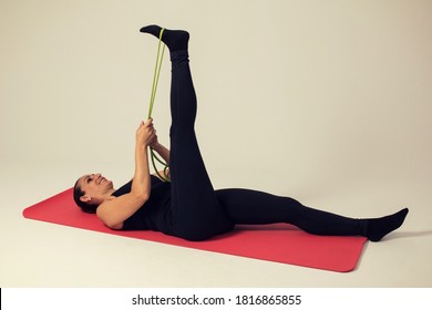 fitness woman with elastic bands doing hamstring stretch - Shutterstock ID 1816865855