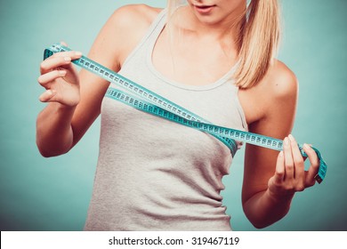 Fitness woman fit girl in sportswear with measure tape measuring her size chest breast on blue