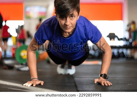 Fitness Woman In The Gym.
Concentrated caucasian woman wearing sports clothes working out in the gym doing plank position.