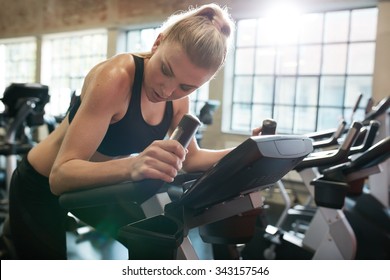 Fitness Woman On Bicycle Doing Cardio Workout At Gym. Fit Young Female Exercising On Gym Bike.