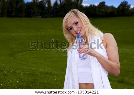 Fitness woman outdoors. Young blond fitness woman taking a brake outdoors after some exercise.