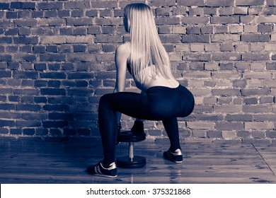 Fitness Woman Performing Deadlift With Dumbbell At The Gym, View From The Back