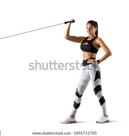 Fitness woman performs exercises with resistance band. Fitness model in sportswear isolated on white background 