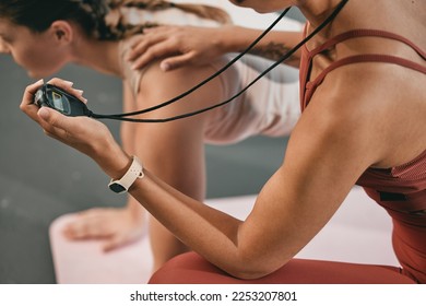 Fitness, woman and personal trainer at gym with a stopwatch for workout exercises or training. Girls, challenge or healthy sports athlete exercising with support or motivation for record on timer - Powered by Shutterstock