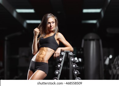 Fitness Woman Posing In The Gym. Perfect Physique Athletic Young Woman With Six Pack, Perfect Abs, Shoulders And Biceps. Crossfit Woman