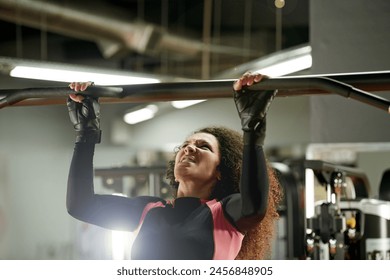 Fitness, woman and pull up exercise at gym on bar for muscle, wellness or healthy body. Chin up, training and strong female person with equipment at club for power, workout and sports for bodybuilder - Powered by Shutterstock