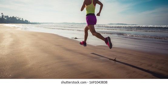 Fitness Woman Runner Running On Sunrise Beach 