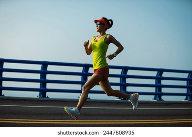 Fitness woman runner running on seaside bridge - Powered by Shutterstock