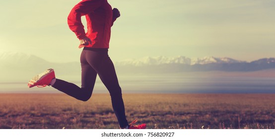 Fitness woman runner running on country road