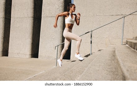 Fitness Woman Running Up On Steps. Side View Shot Of Female Runner Athlete Going Up Stairs.