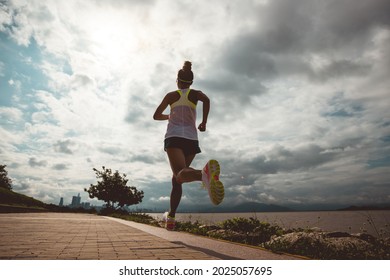 Fitness Woman Running On Sunny Coast Trail