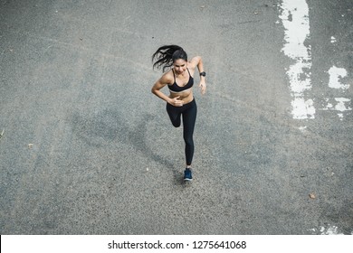 Fitness Woman She Is Running The Road. Top View